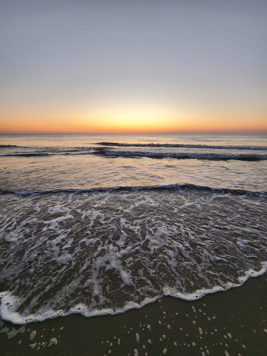 A sun rising on a sandy beach